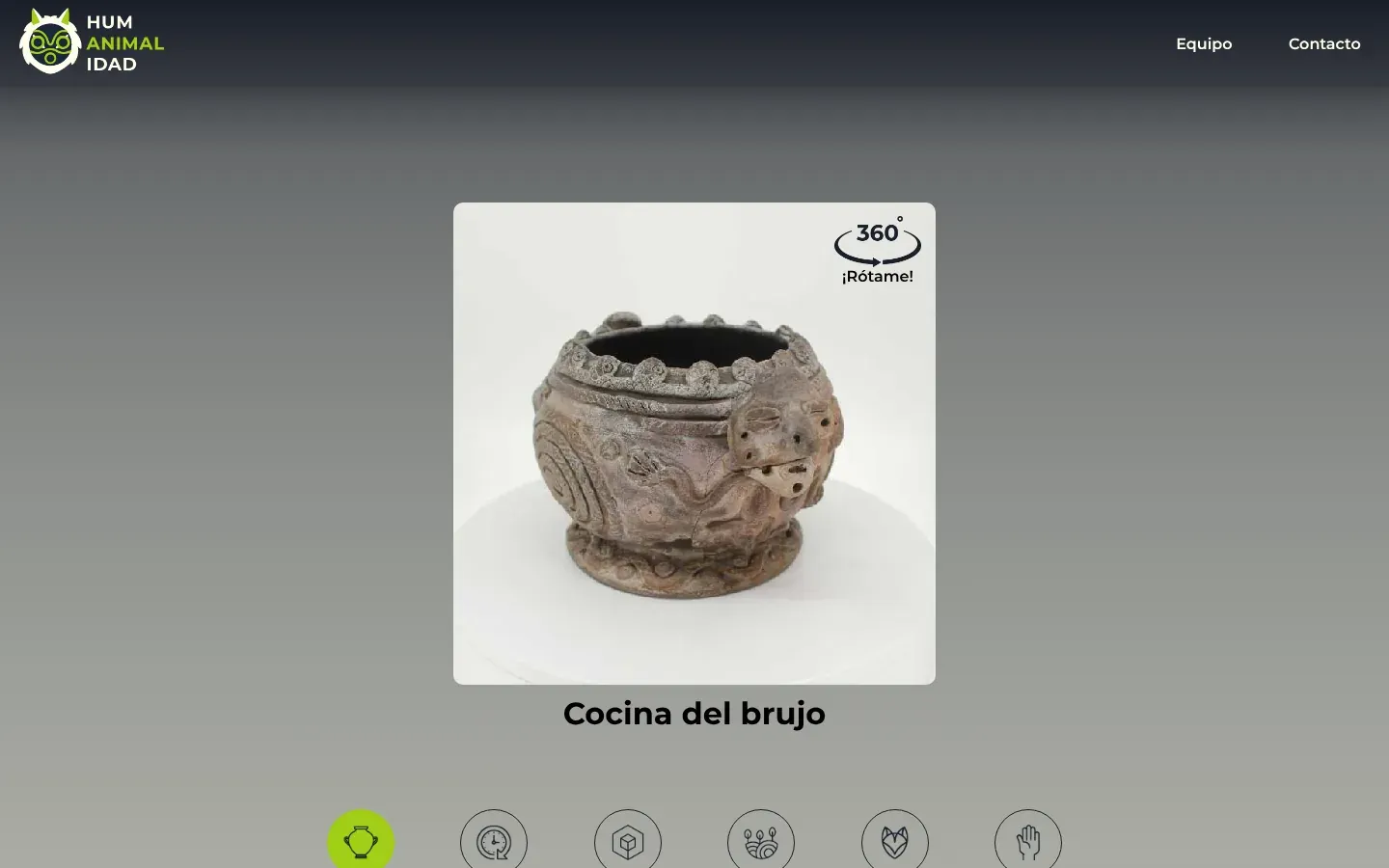 A piece page from Humanimalidad on desktop: a dark header with the HUM ANIMAL IDAD owl logo, then a square viewer showing a grey ceramic pot covered in spirals and small snake heads, turned so a modelled human face on its side shows at the right. A 360° ¡Rótame! badge sits in the corner, the title Cocina del brujo is below, and a row of round icon tabs starts at the bottom.